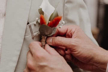 Boutonnière du marié fixée sur le costume Boutonnière du marié fixée sur le costume